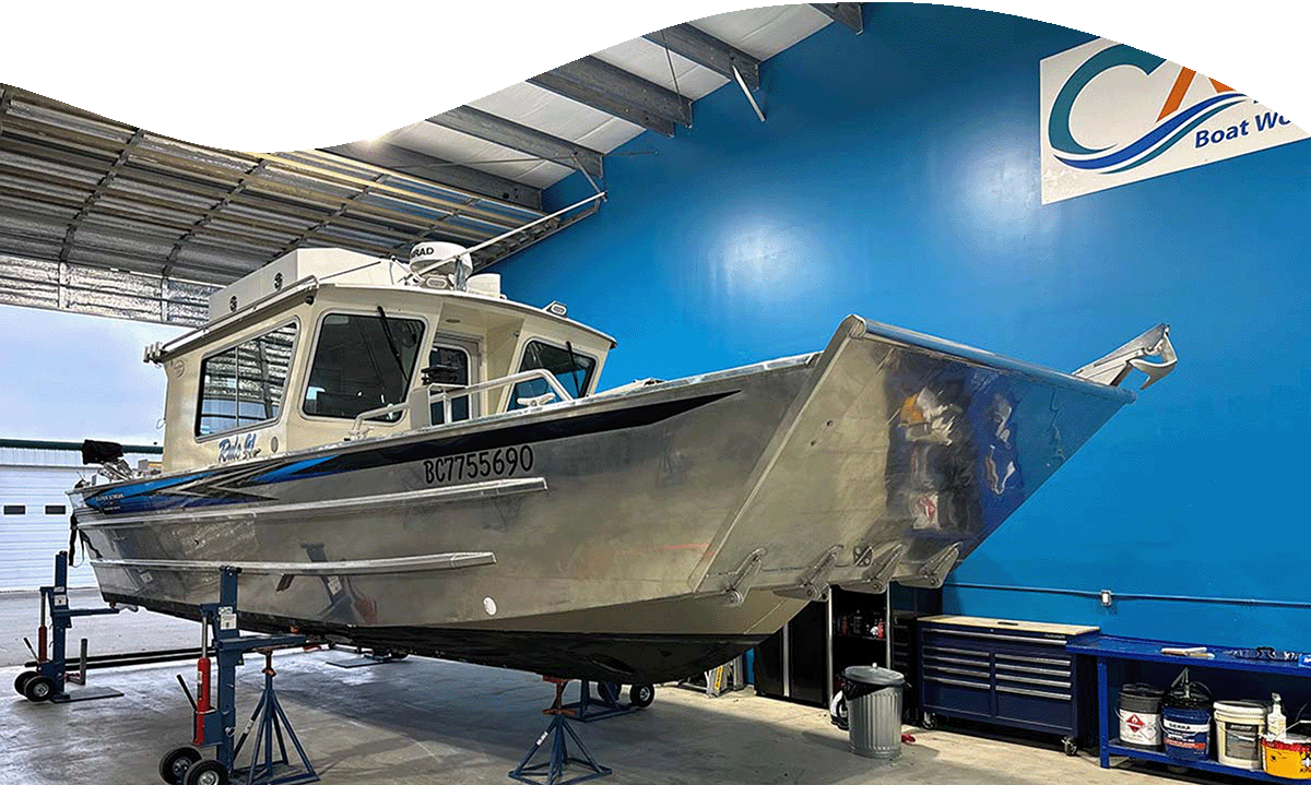 Boat inside Cape Boat Works shop with blue walls in behind